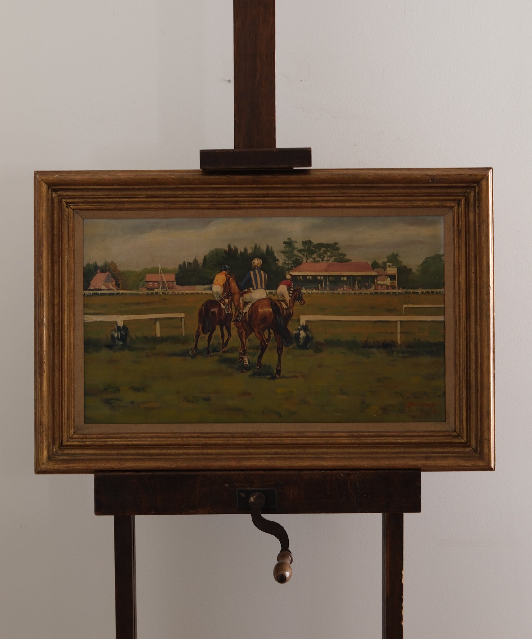 Painting of horses on a grassy field with a wooden frame and stand.