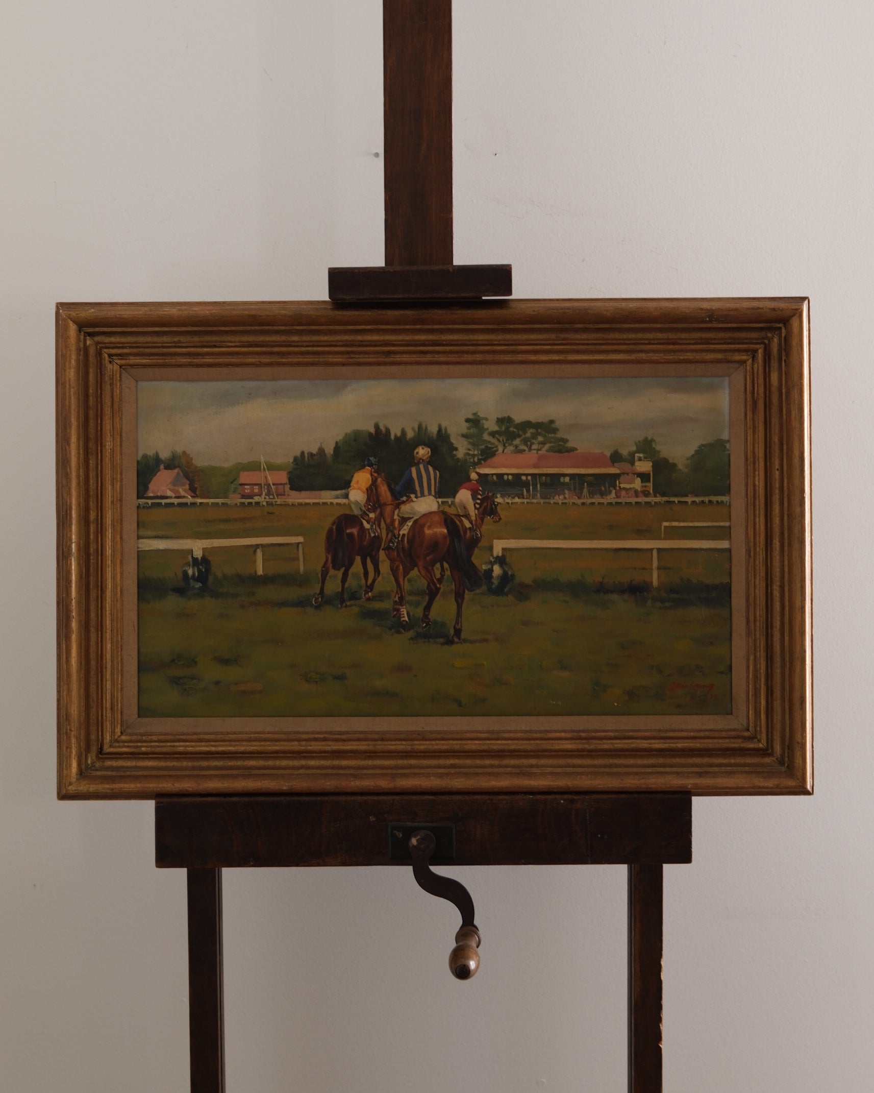 Painting of horses on a grassy field with a wooden frame and stand.