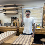 Man standing in a workshop with a wooden cutting board