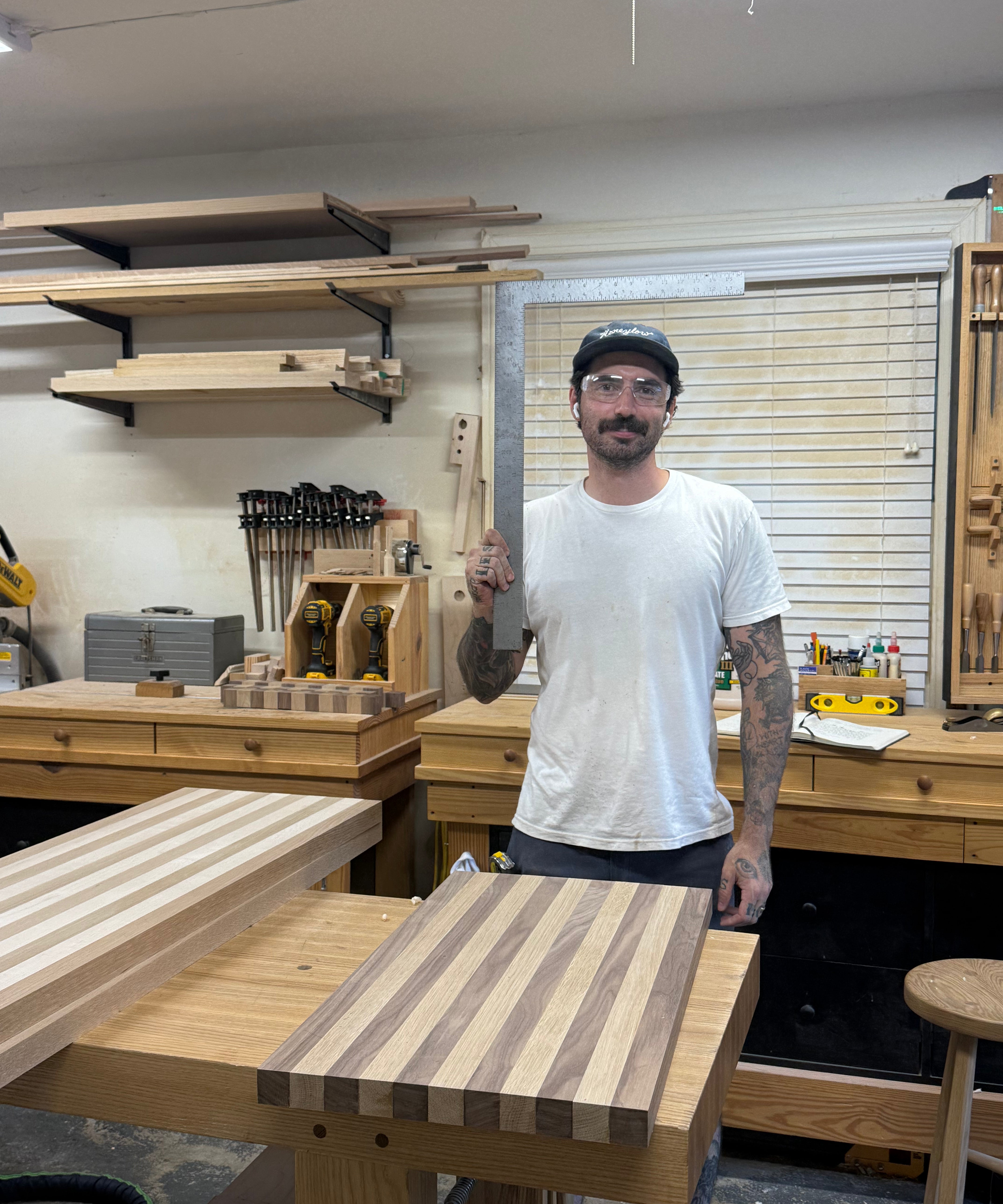 Man standing in a workshop with a wooden cutting board