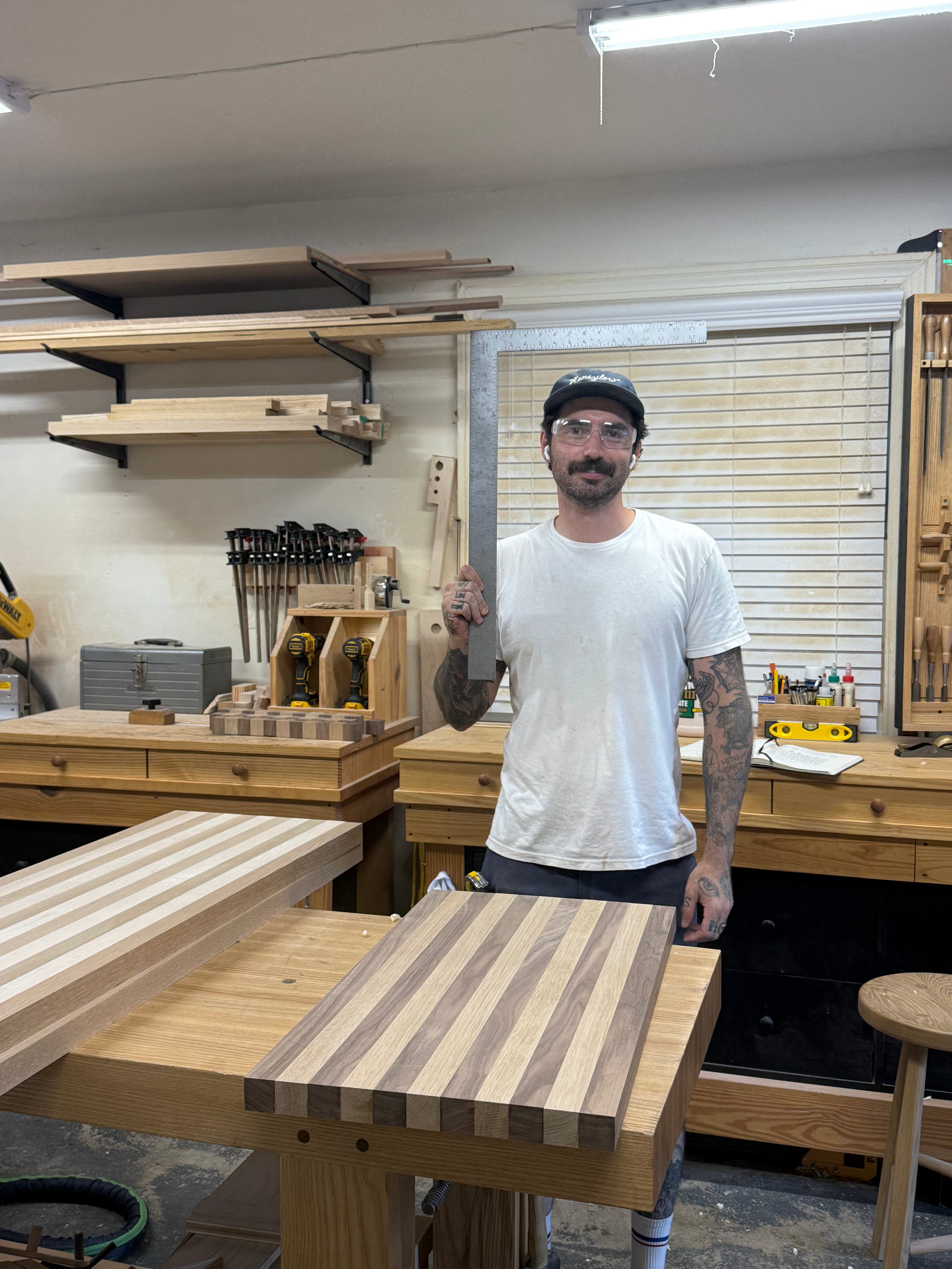 Man standing in a workshop with a wooden cutting board